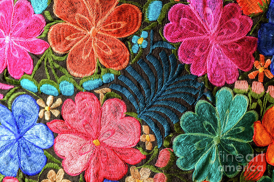 Background of hand-embroidered flowers on a fabric with colored threads. Photograph by Joaquin Corbalan