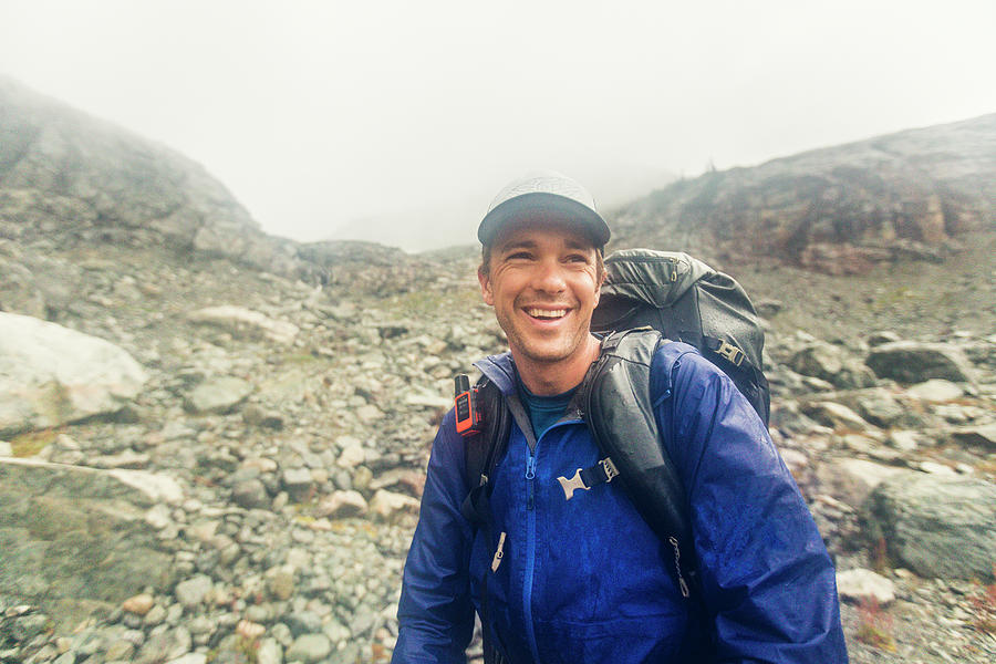 Mountain Photograph - Backpacker Smiling Despite Bad Weather, Rain And Wind. by Cavan Images