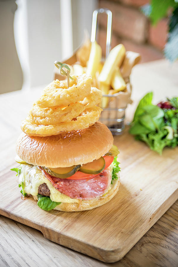 Bacon Cheese Beef Burger With Gherkins, Pickle, Tomato, Fresh Salad, Bacon, Cheese And Fried Onion Rings Ona Wooden Board With Chips And Salad Photograph by Giulia Verdinelli Photography