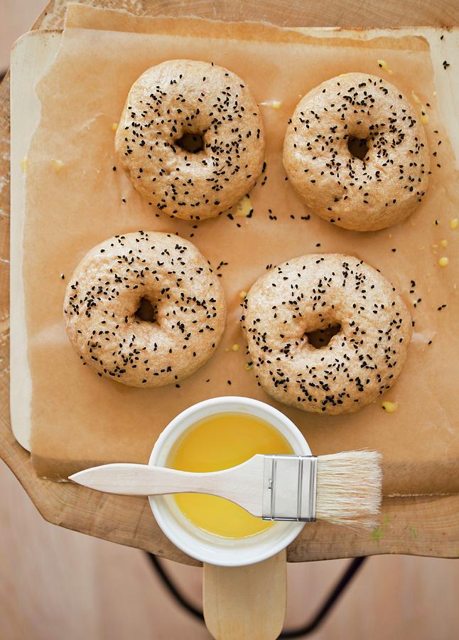 Bagels With Black Caraway Seeds On A Piece Of Baking Paper Photograph by Dorota Indycka