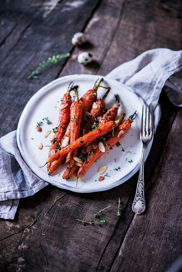 Baked Carrots With A Honey-thyme Glaze And Almond Flakes Photograph by Carolin Strothe