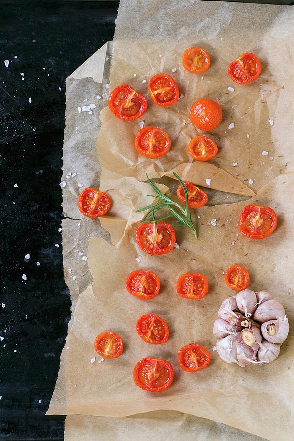 Baked Cherry Tomatoes With Salt And Garlic On Backing Paper Photograph by Natasha Breen