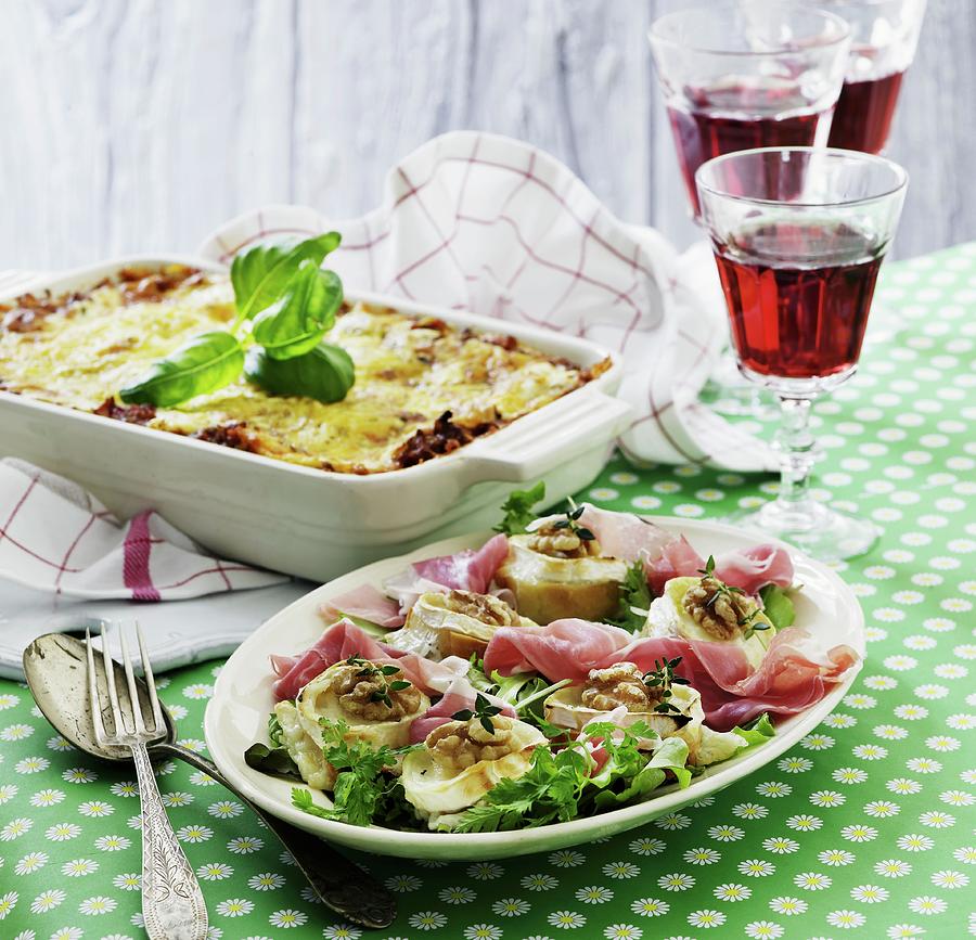 Baked Goats Cheese With Walnuts On A Parma Ham Salad With A Lasagne In The Background Photograph by Mikkel Adsbl