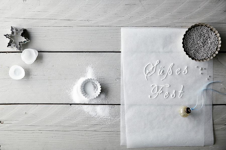 Baking Tins, Cutters, Decorative Pearls, A Bauble And German Words Written On Baking Paper Photograph by Mona Binner Photographie