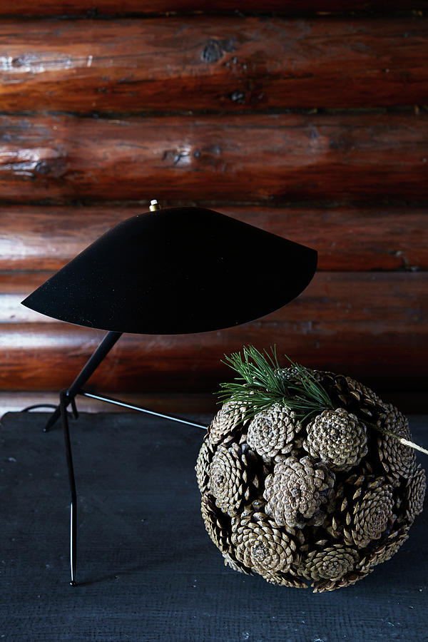 Ball Of Pine Cones Below Black Table Lamp Photograph by Birgitta Wolfgang Bjornvad