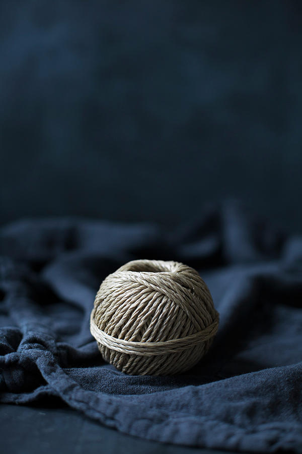 Ball Of String On Blue Fabric Photograph by Alicja Koll