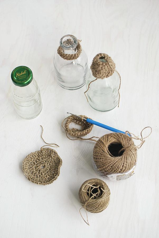 Balls Of String, Crochet Hook And Glass Bottles With Crocheted Trim Photograph by Patsy&christian