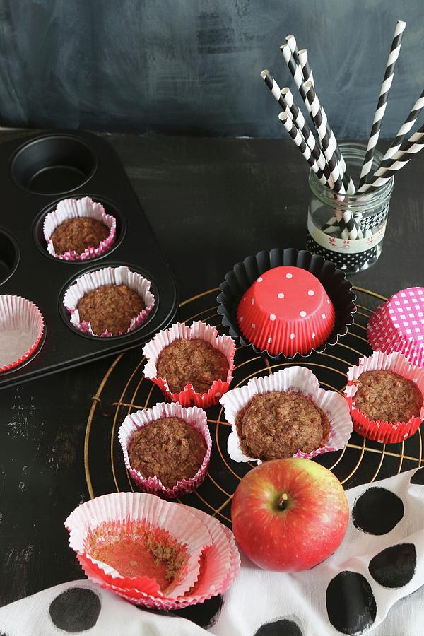 Banana And Apple Muffins gluten-free On A Wire Rack With A Glass Of Straws In The Background Photograph by Regina Hippel