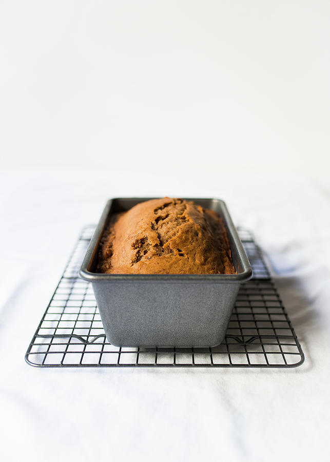Banana Bread Cooling In A Loaf Tin Against A White Background Photograph by Lisa Rees