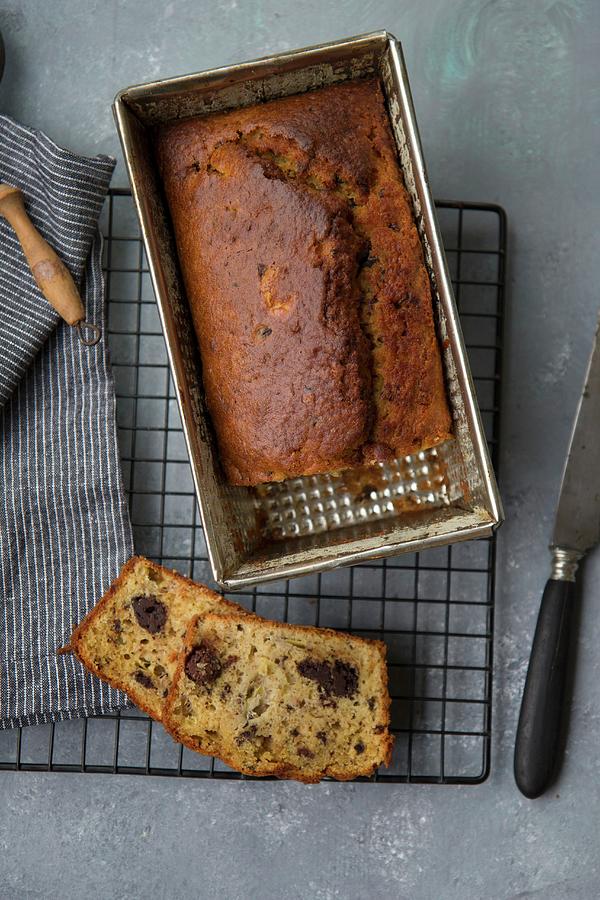 Banana Bread With Chocolate Pieces In A Baking Tin On A Cooling Rack top View Photograph by Patricia Miceli