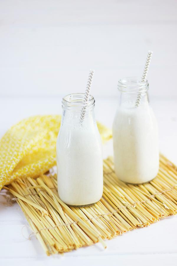 Banana Smoothies In Glass Bottles With Straws Photograph by Vernica Orti