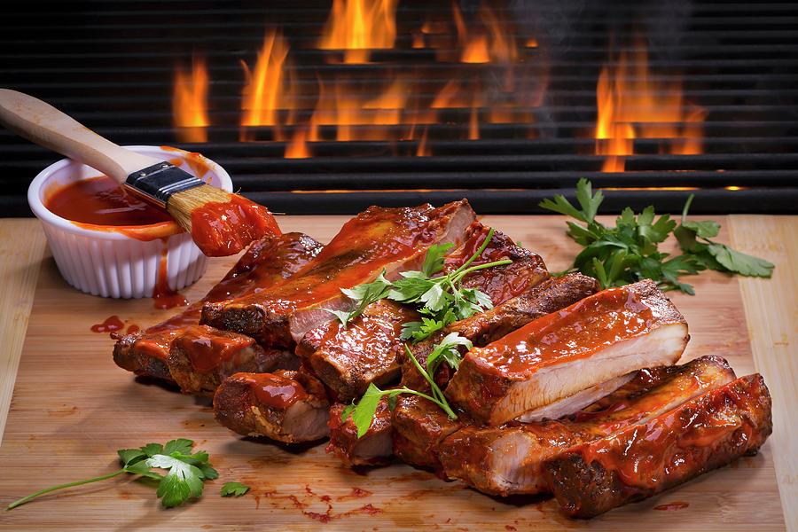 Barbecue Spare Ribs On A Wooden Board In Front Of A Fire Photograph by Brian Enright