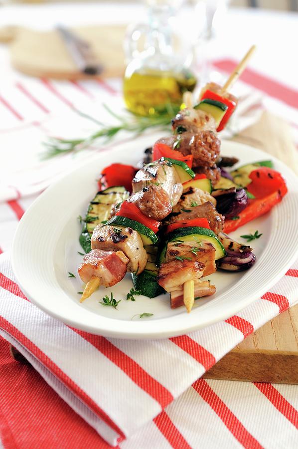 Barbecued Kebabs With Sausage, Bacon And Pancetta On Grilled Vegetables Photograph by Mario Matassa
