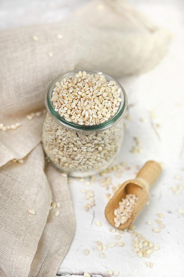 Barley In A Jar And On A Wooden Scoop Photograph by Claudia Gargioni
