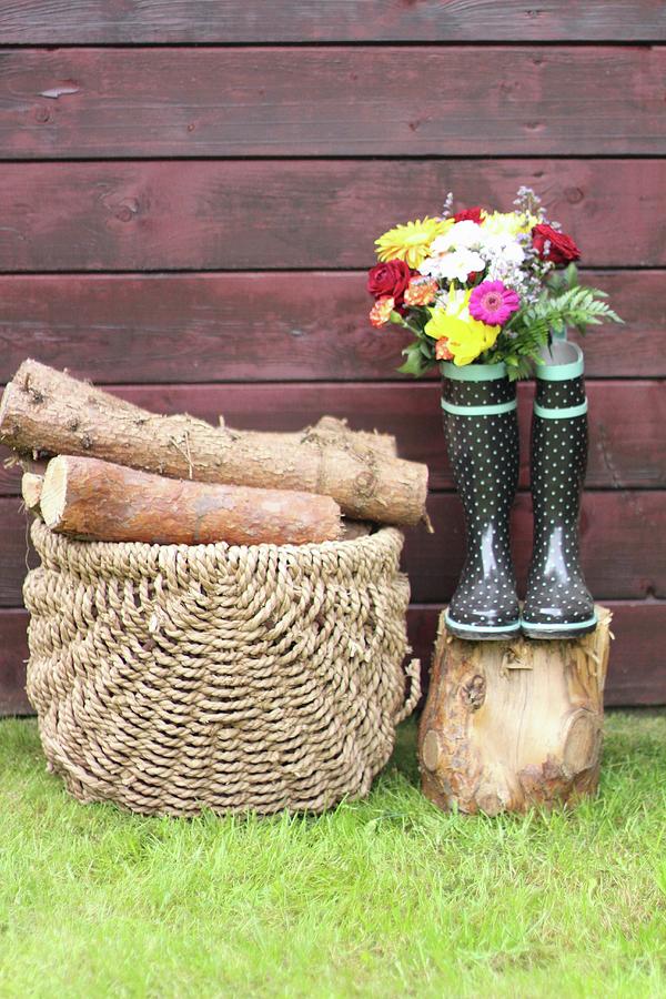 Basket Of Firewood Next To Flowers In Wellington Boots Photograph by Sylvia E.k Photography