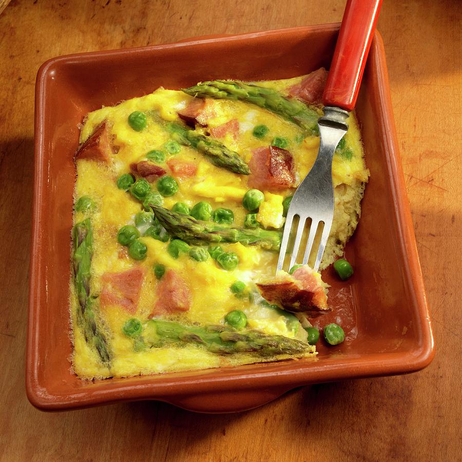 Basque Eggs With Ham, Peas And Asparagus With A Bite Take Out Photograph by Paul Poplis
