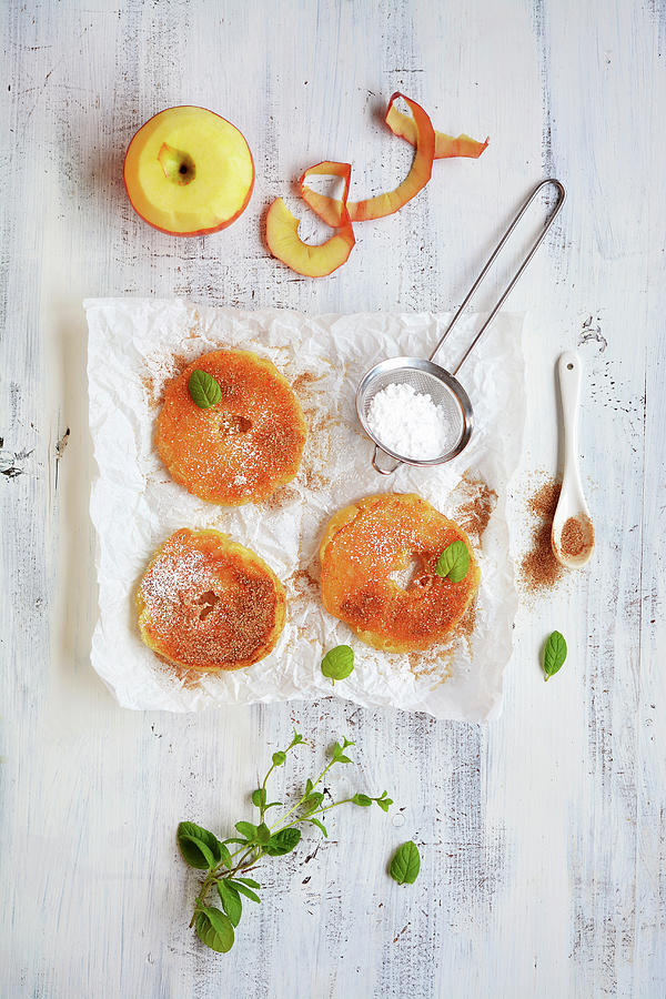 Battered Apple Rings With Icing Sugar, Cinnamon And Mint On A Piece Of Paper Photograph by Mariola Streim