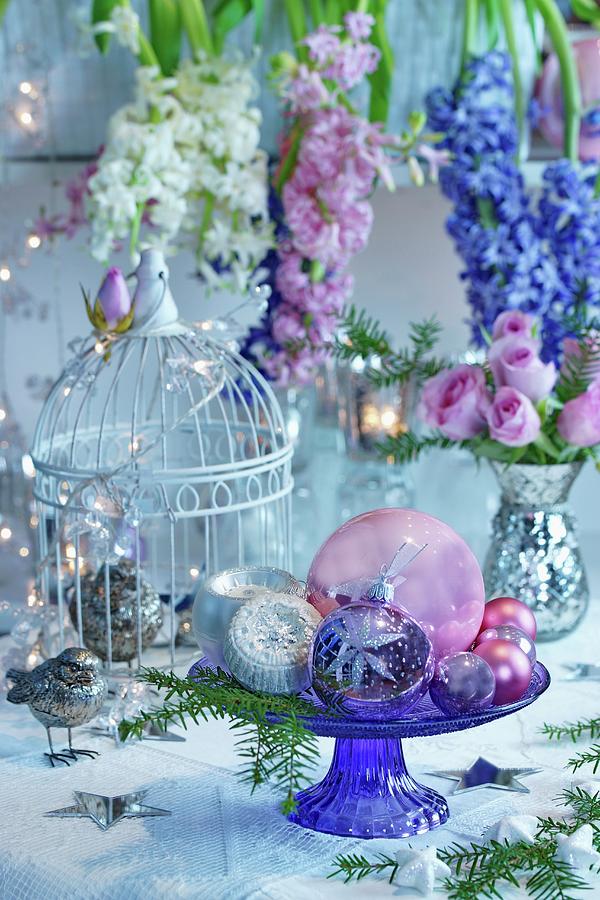 Baubles On Glass Cake Stand In Front Of Flower Arrangement Of Hyacinths And Roses In Mercury Silver Vase Photograph by Angelica Linnhoff