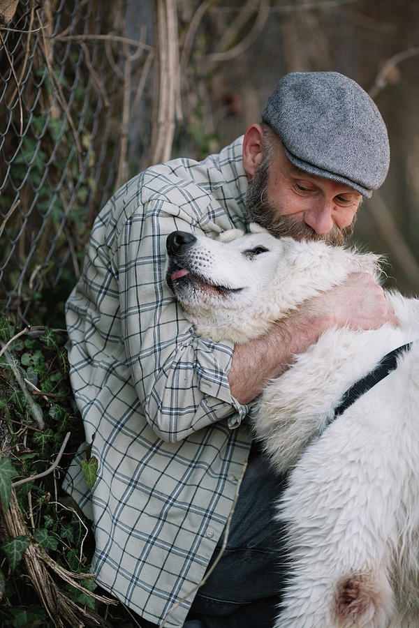 Nature Photograph - Bearded Man Hugging White Fluffy Dog by Cavan Images