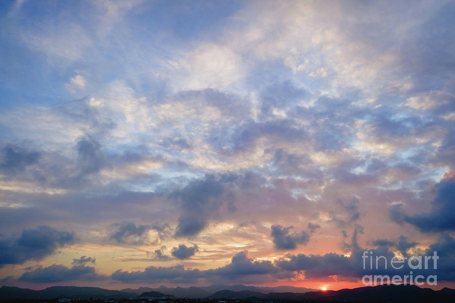 Beautiful sunset with a cloud sky and spectacular sun rays. Photograph by Joaquin Corbalan