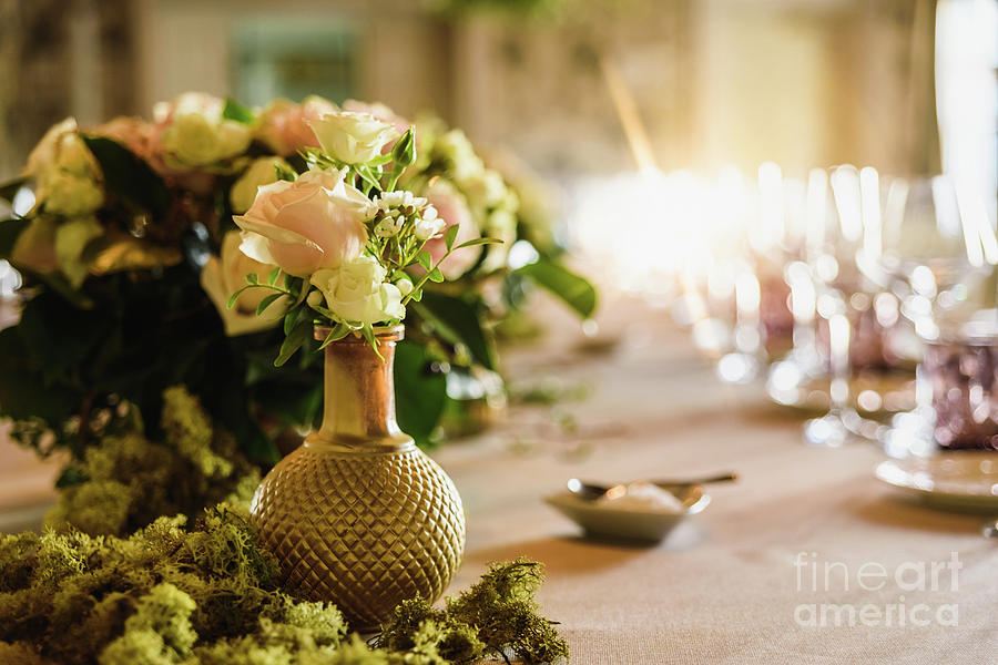 Beautiful vintage vases with roses as centerpieces of decorating tables of a wedding. Photograph by Joaquin Corbalan