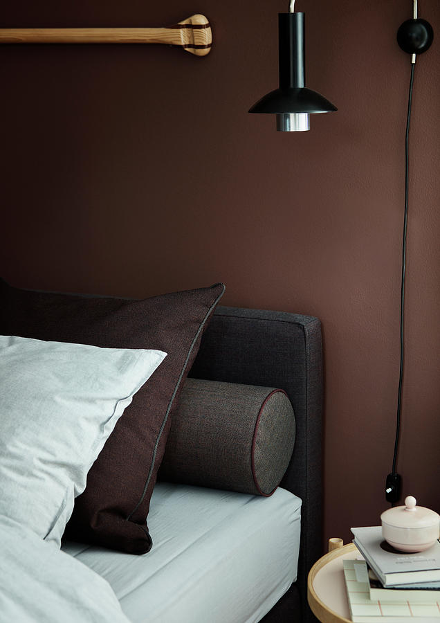 Bed With Pillows And Bolster Against Brown Wall Photograph by Bjarni B. Jacobsen