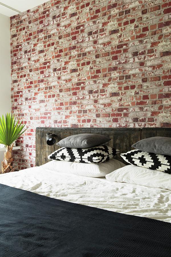 Bed With Rustic Headboard Against Brick Wall In Bedroom Photograph by ...