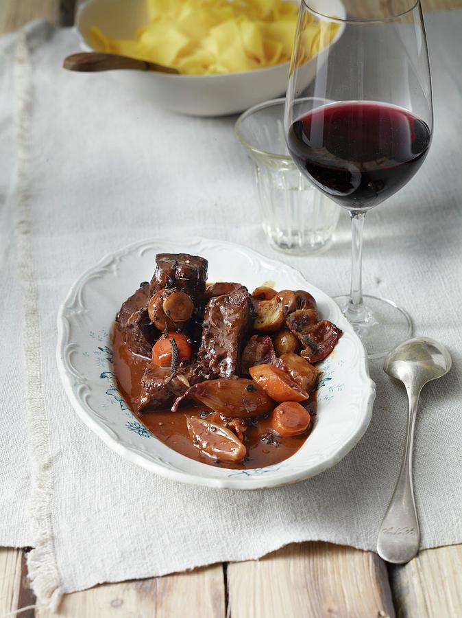Beef Bourguignon With A Glass Of Red Wine And Ribbon Noodles Photograph by Nikolai Buroh