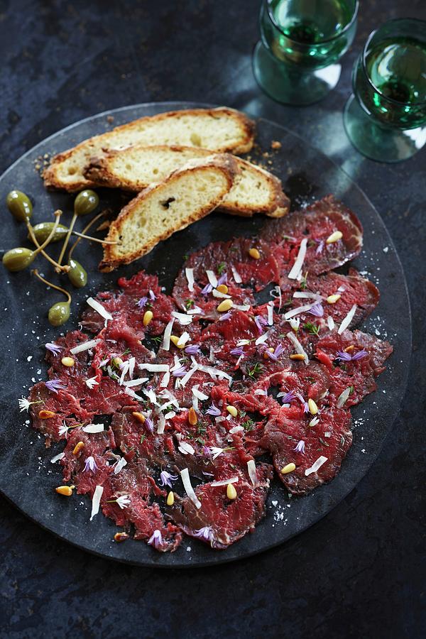 Beef Carpaccio With Pine Nuts, Grated Cheese, Edible Flowers, Capers And Bread Photograph by Charlotte Tolhurst
