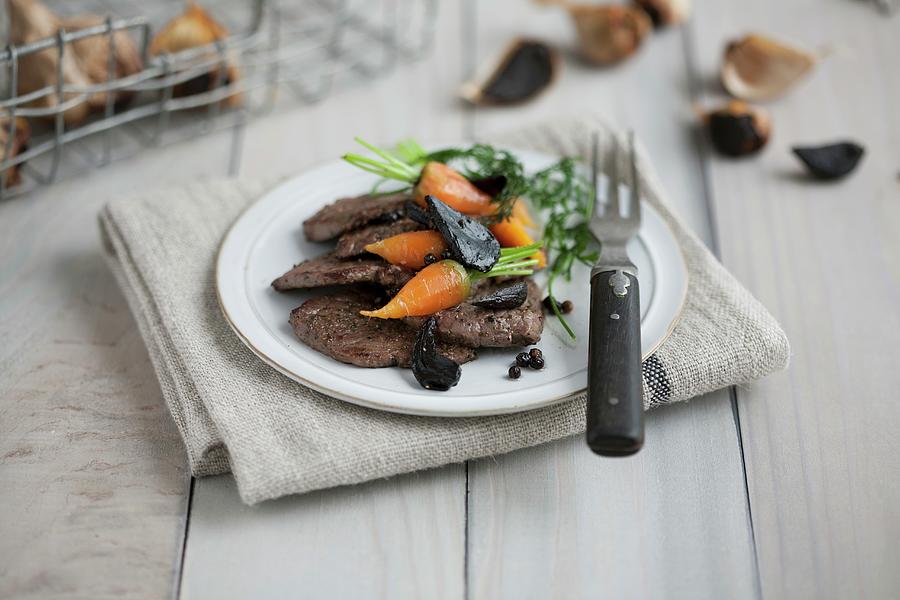 Beef Fillet With Baby Carrots And Black Garlic Photograph by Schindler, Martina