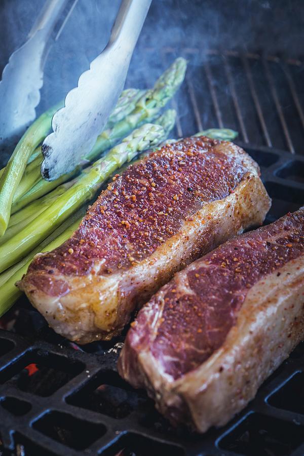 Beef Steak And Green Asparagus On The Barbecue Photograph by Eising Studio