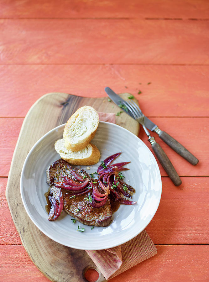 Beef Steaks With Balsamic Onions And Baguette Slices Photograph by Peter Rees
