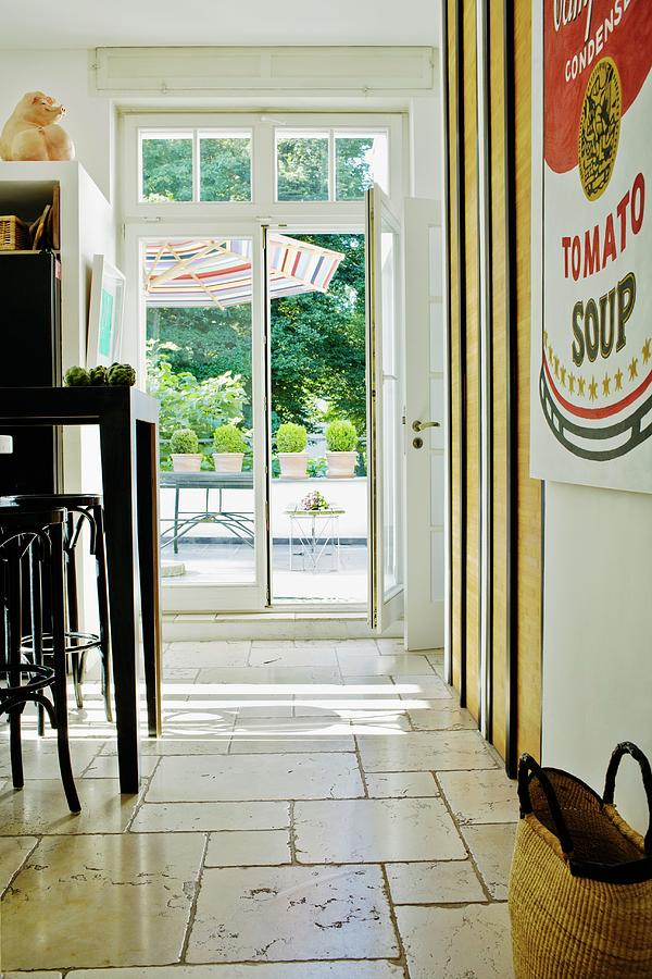 Bentwood Stools At Black Counter In Kitchen With Limestone Flags; View Of Terrace Through French Windows Photograph by Pics On-line / June Tuesday