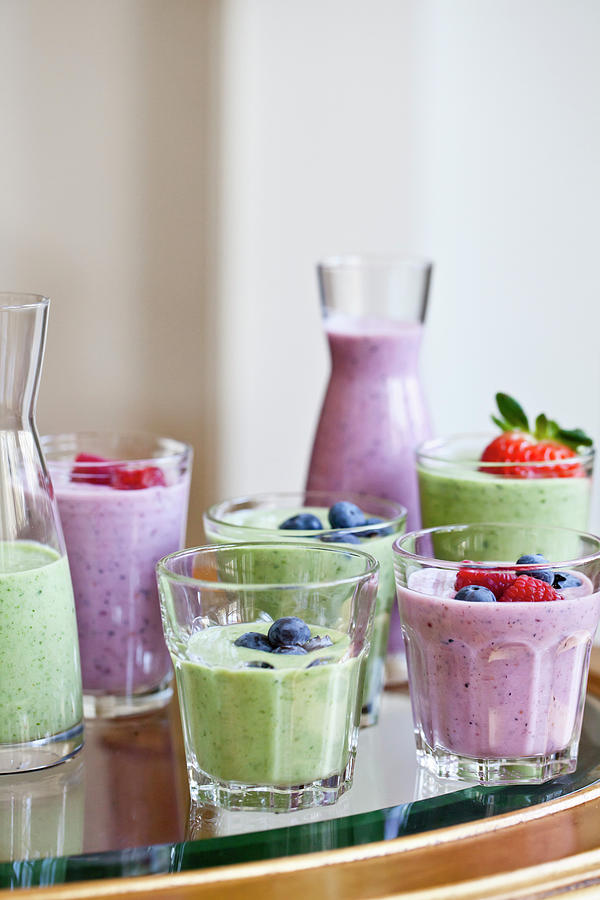 Berry Smoothies And Green Smoothies In Various Cups And Carafes, Topped With Fruit Photograph by Ryla Campbell