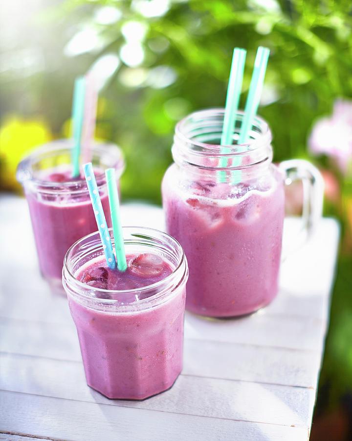 Berry Smoothies On A Table In A Garden Photograph by Tom Regester