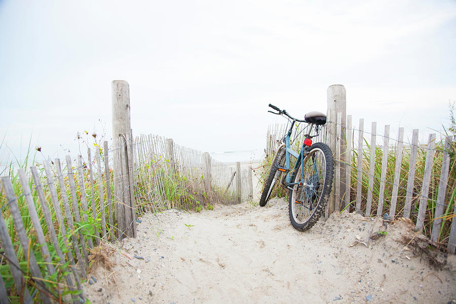 Bicycle Leaning On Beach Fence Photograph by Jacqueline Veissid