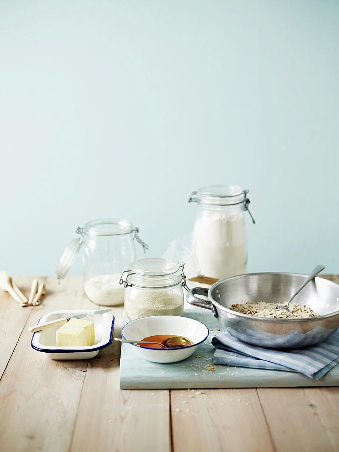 Biscuit Ingredients In Various Jars And Bowls, On A Wooden Tabletop Photograph by Will Shaddock Photography