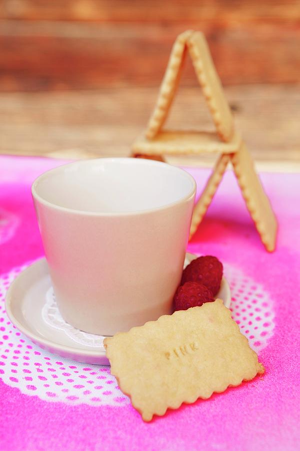 Biscuit Next To White Cup And Saucer On Place Mat Sprayed Hot Pink Through Doily Stencils Photograph by Nikky Maier
