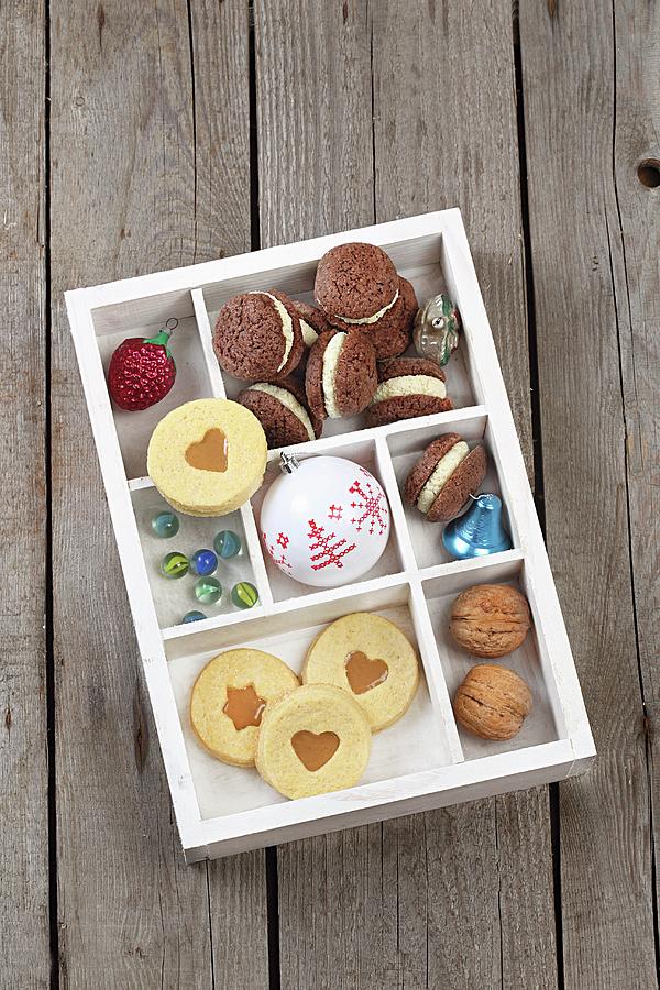 Biscuits, Christmas Decorations And Nuts In A Seedling Tray Photograph by Zita Csig