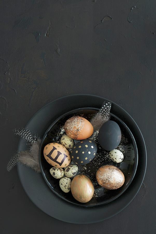 Black And Gold Easter Eggs, Feathers And Quail Eggs In Black Bowl Photograph by Ulla@patsy
