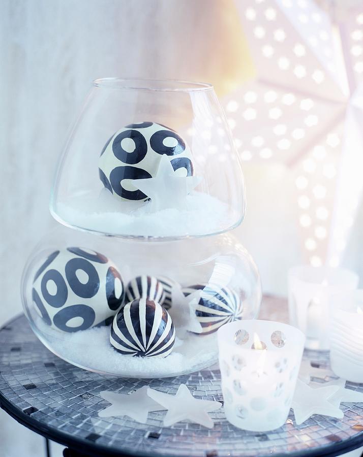 Black And White Patterned Baubles In Glass Vessels On Mosaic-tiled Table Photograph by Matteo Manduzio