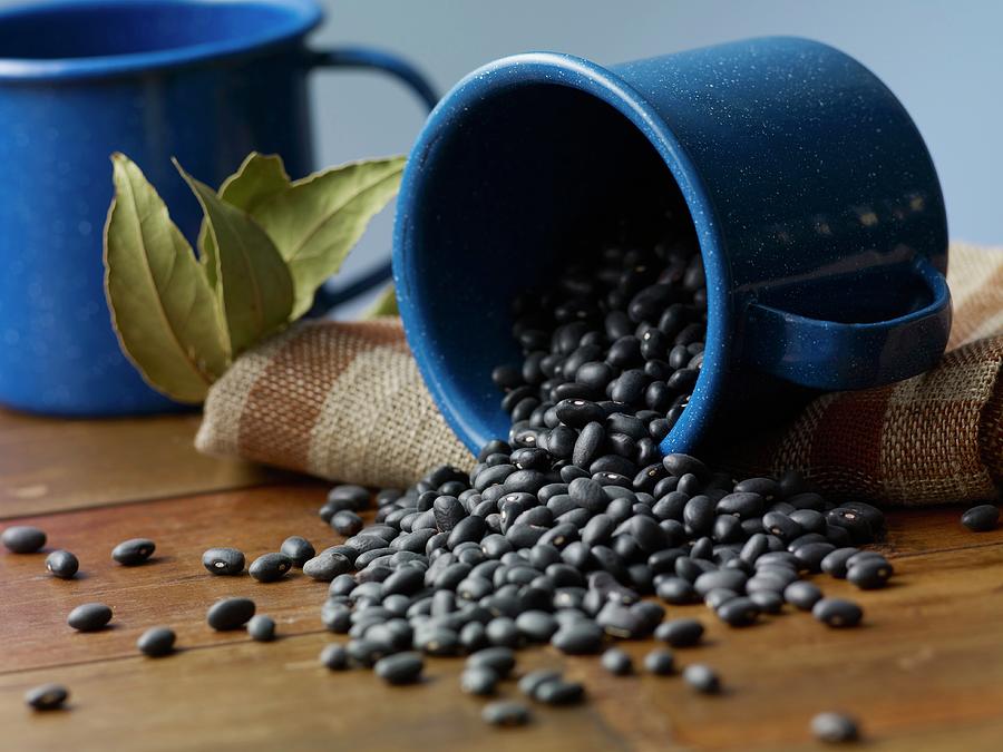 Black Beans Falling From An Enamel Mug Photograph by Studio R. Schmitz