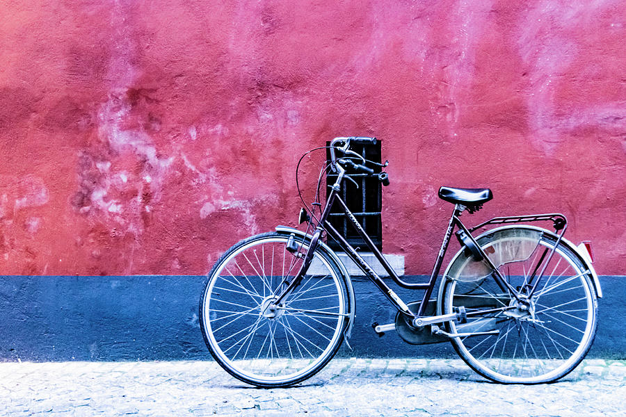 Black bicycle near a red and blue painted wall with a small window Photograph by Vlad Baciu