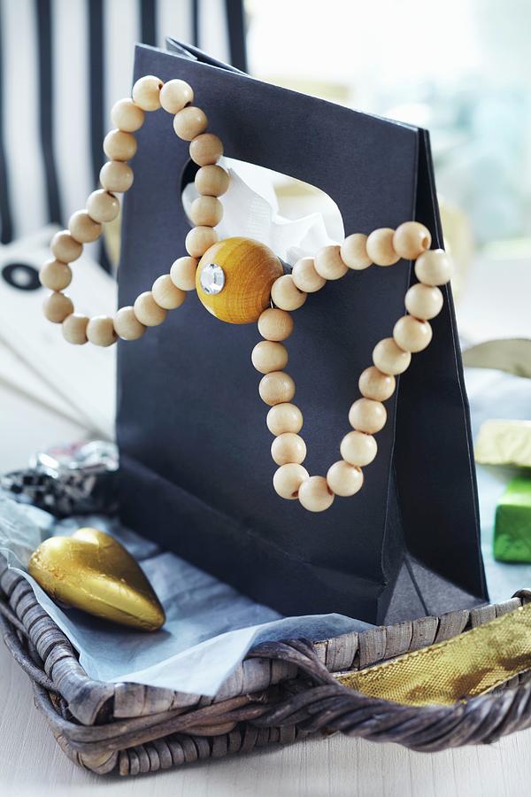 Black Gift Bag Decorated With Bow Made From Wooden Beads Photograph by Franziska Taube