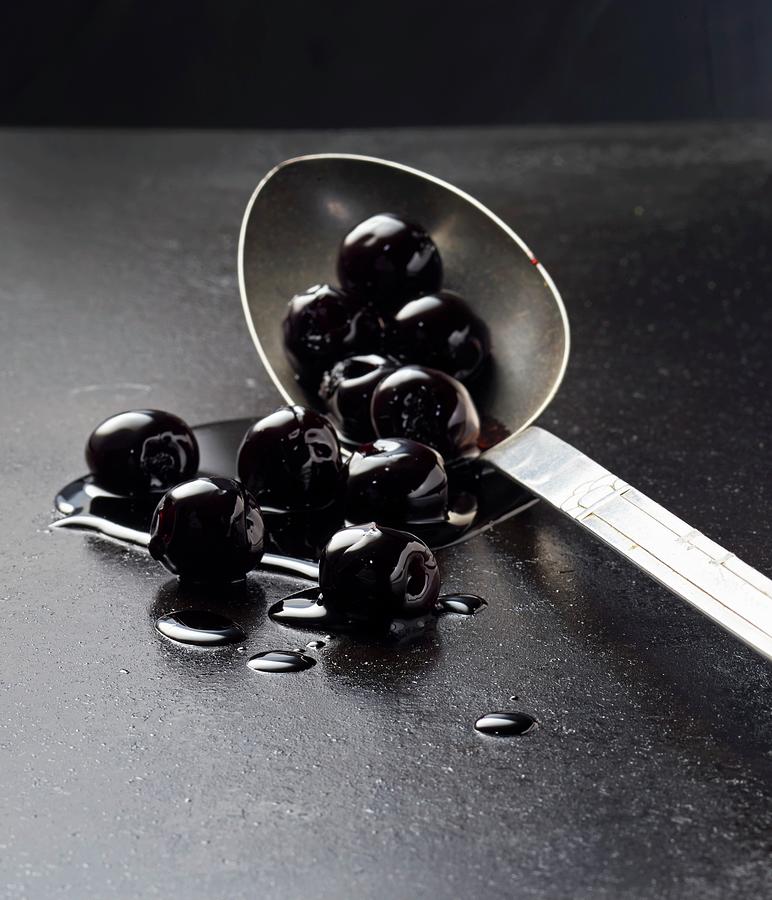 Black Olives On A Spoon Photograph by Ludger Rose
