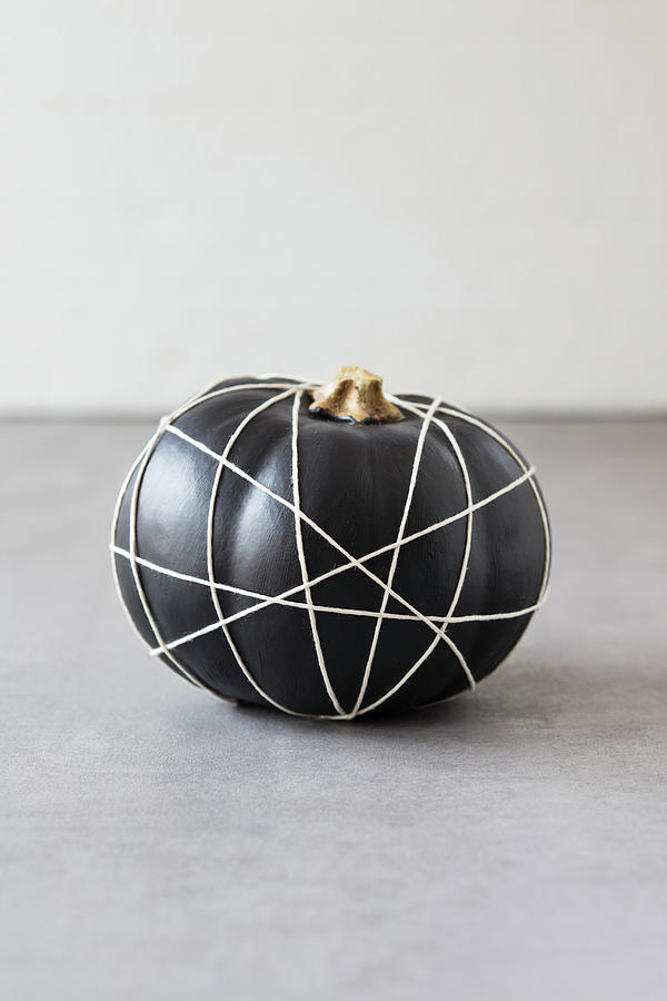 Black-painted Pumpkin Wrapped In Criss-crossing String Photograph by Jan Wischnewski