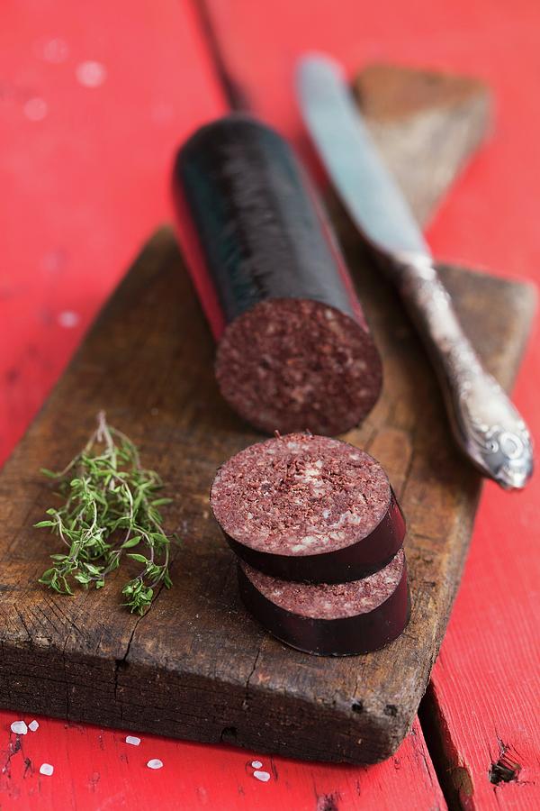 Black Pudding, Sliced, And Fresh Thyme On A Chopping Board Photograph by Aniko Takacs