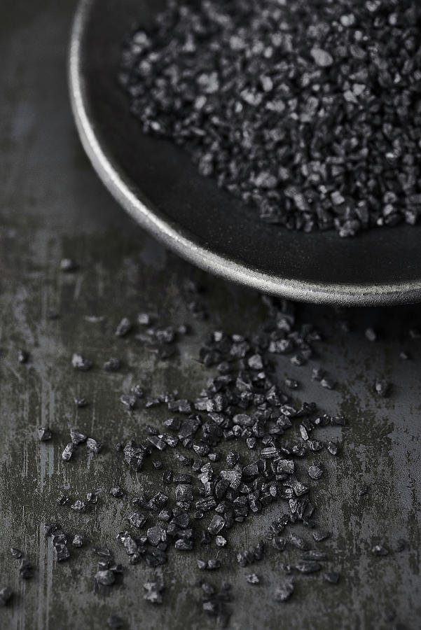 Black Salt In A Black Bowl On A Metal Surface Photograph by Sylvia Meyborg