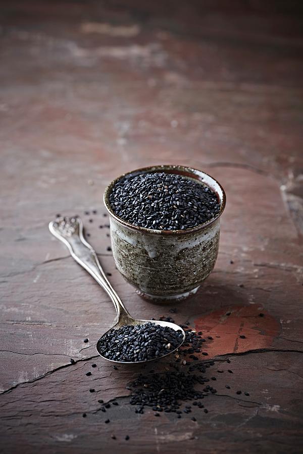 Black Sesame Seeds On A Spoon And In A Pot Photograph by B.&.e.dudzinski