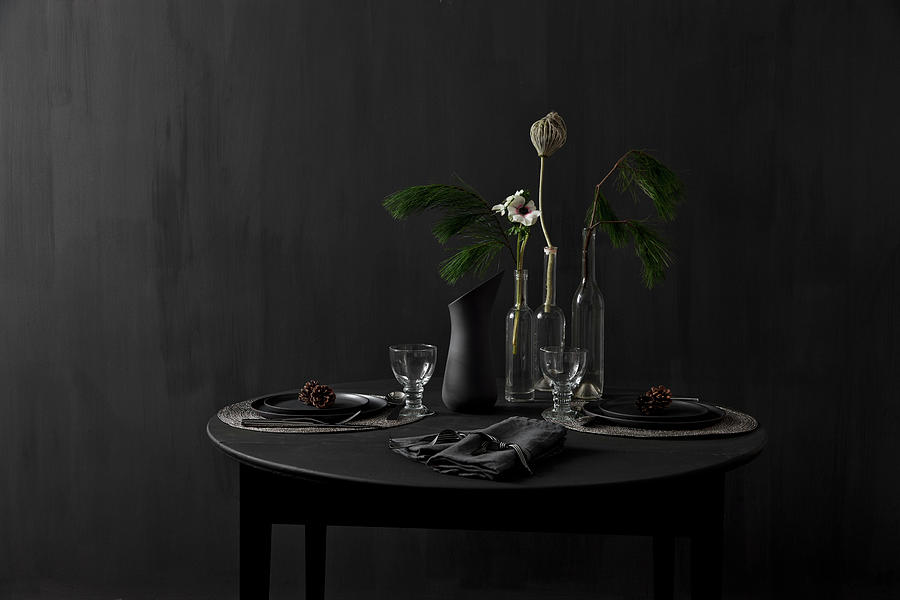 Black Table Set For Dinner And Decorated With Larch Branches Against Black Wall Photograph by Lykke Foged & Morten Holtum